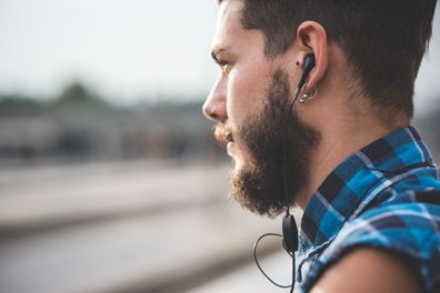 Young man listening to music on earbuds