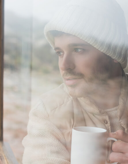Depressed man suffering from insomnia looking out of window
